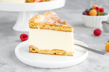 Traditional Polish cake Karpatka on a gray concrete background. Cake of choux pastry dough and...