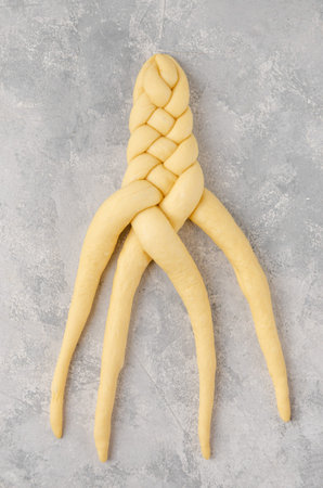 Raw loaf of challah Jewish bread on a light gray background. top view, copy space