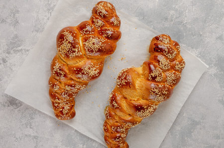 Homemade challah bread with sesame seeds on a gray concrete background. sweetbread. selective focus