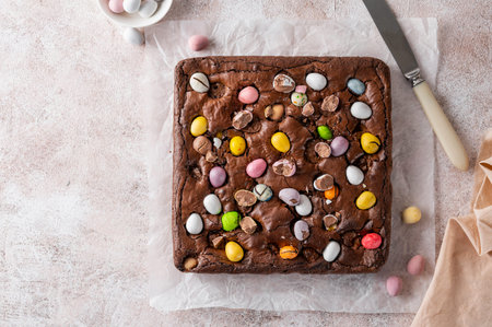 Chocolate brownie with Easter candies in the form of colored eggs with a bottle of milk. Easter...