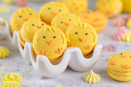 Cute Easter chick macarons. French macarons with vanilla cream and lemon curd on a concrete...