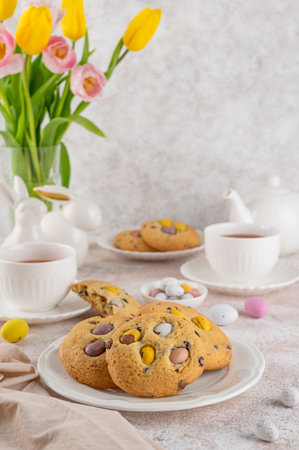 Easter cookies. Tradition american cookies with chocolate mini eggs candy on a white plate. Easter dessert. Copy spaceの写真素材