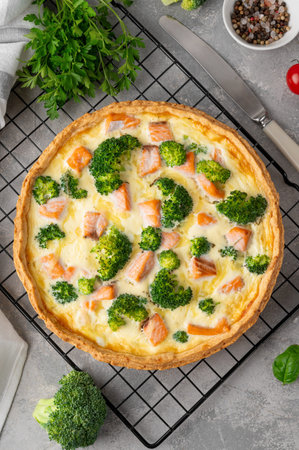 Homemade tart or quiche with salmon, broccoli, cheese and cream filling on a gray stone background. Healthy food. Selective focusの写真素材