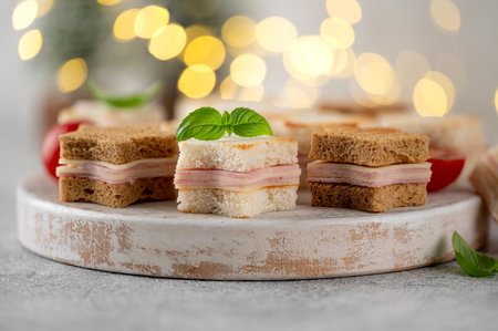 Christmas star shaped cheese and ham mini sandwiches on a wooden board on a gray background. Festive food. Selective focusの写真素材