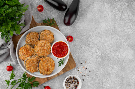 Baked garlic crispy eggplant with tomato sauce on a plate. Vegetarian food. Selective focus, top viewの写真素材