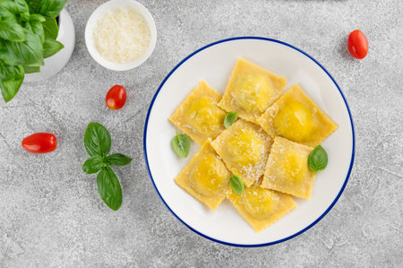 Italian ravioli pasta with spinach, ricotta, parmesan cheese and fresh basil on a gray concrete background. Top viewの写真素材