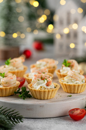 Christmas food. Tartlets with shrimp, cream cheese, garlic and parsley on a wooden board on gray concrete backgroundの写真素材