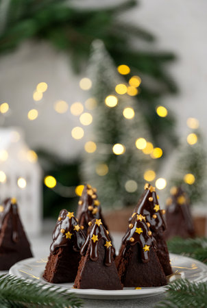 Chocolate brownie Christmas tree with chocolate glaze and sugar sprinkles on top on a white plate. Christmas or New Year festive dessert. Copy spaceの写真素材