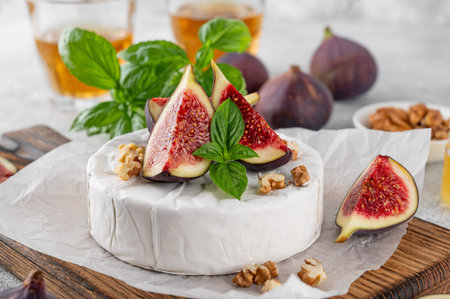Camembert, brie cheese, walnuts, fresh figs and honey on a cutting board on a concrete background. Top view.の写真素材