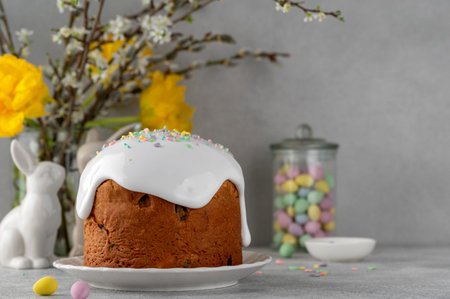 Easter sweet bread or Easter cake - Paska with white sugar glaze and colored sprinkles on top on a...