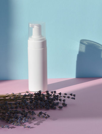 A white plastic jar stands on a wooden podium with dried lavender flowers. A mock-up of a cosmetic skin care product. The concept of eco-organic cosmetics with natural extracts.の写真素材