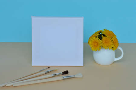 Dandelion bouquet in a vase and picture frame with copy space for mockup on a blue background. A set of brushes for drawingの写真素材