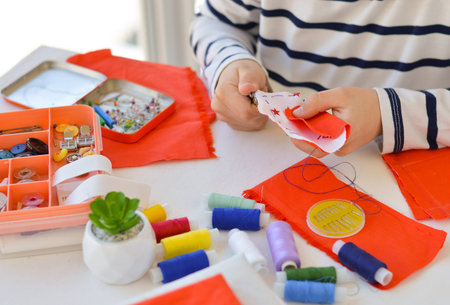 Close-up of a beautiful 9-year-old Caucasian boy who studies to sew, additional education, leisure.