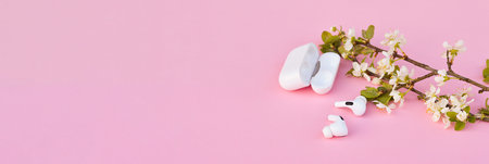 Banner with modern wireless ear phones sounds like flowers. A minimalist concept for spring or...