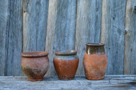 Three empty clay pot on a wooden table in gardenの写真素材