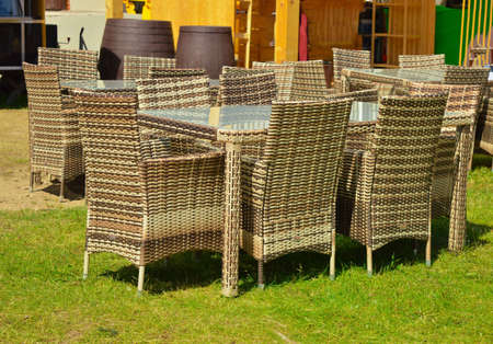 Brown wicker furniture stands on the grass outside on a sunny summer day. The concept of recreation.の写真素材