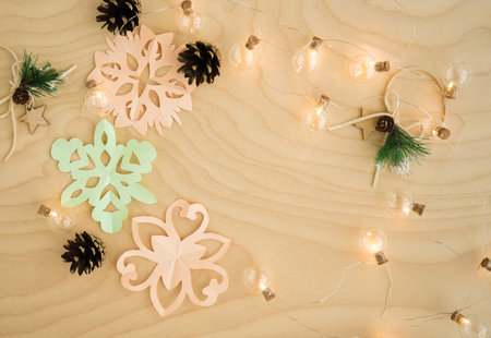 Colorful paper snowflakes cutouts, on a wooden background. Cutting snowflakes from colored paper....