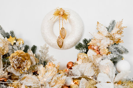 A traditional bright Christmas wreath hanging over the fireplace, on a white wall. Christmas decoration concertの写真素材