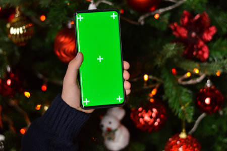 Child holding smartphone with green screen for modern technology on mockup template, watching digital device with chroma key to view background design.の写真素材