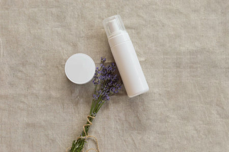 flat lay organic lavender flowers, moisturizer cream on flaxen background. The concept of beauty and wellness. Skin care and bodyの写真素材