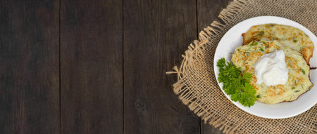 Zucchini pancakes with parsley on a wooden table. Vegetarian foodの写真素材