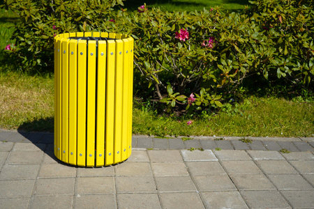 Yellow wooden trash can on the street on the riverbank in the park.の写真素材