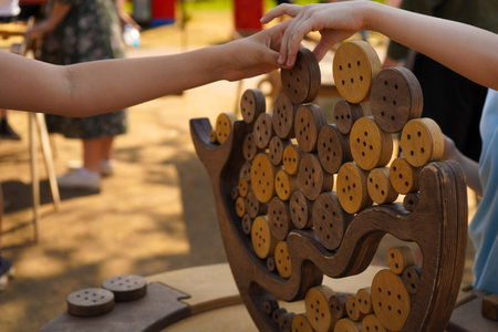 an old wooden game on the outside in which it is necessary to take wooden figurines with chopsticks