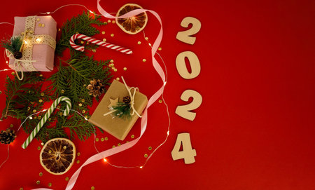 Christmas frame with a Christmas tree and gifts on a green background. Winter holidays. Space for text. Top view, flat lay. Christmas. Template, layout. A greeting card with numbers 2024の写真素材