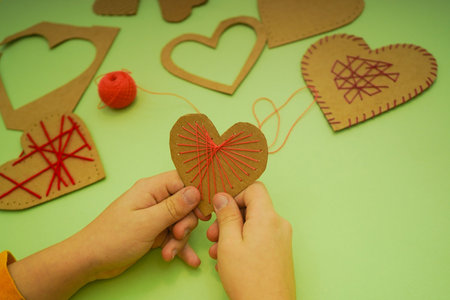 Kids hands hold paper heart. DIY gift for Valentine's Day. Zero waste.の写真素材