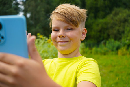 An attractive boy makes a video call on the phone