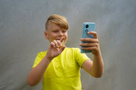 An attractive boy uses a smartphoneの写真素材