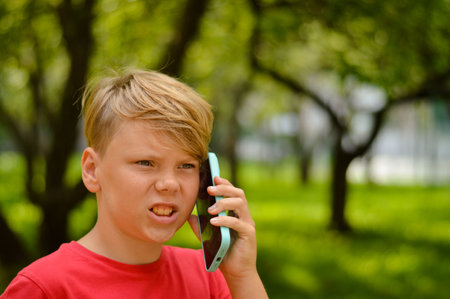 Portrait of a boy who gets angry when talking on the phoneの写真素材