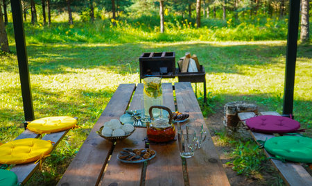 The summer breeze gently moves the tablecloth, while the tea set awaits guests for a delightful outdoor tea experience.の写真素材