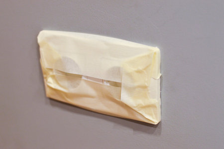 The outlet with sticky tape to protect it from paint during repairs.
