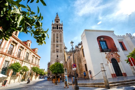 Sevilla, SPAIN - September 10, 2015:  Tower Giralda  of the Cathedral of Saint Mary of the See,  Andalusia. Mandarin tree, tourists in the streetのeditorial素材