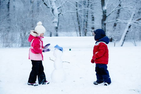 Children shape the snowman. Boy and girl have fun.の写真素材