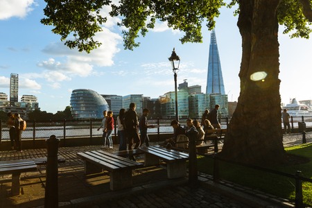 people walk on the embankment near Tower Millennium Pier. Shard and City Hallのeditorial素材