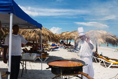 chef prepares a giant seafood paella on beach Varadero near sunbathing touristsのeditorial素材