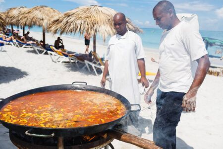 chef prepares a giant seafood paella on beach Varadero near sunbathing touristsのeditorial素材