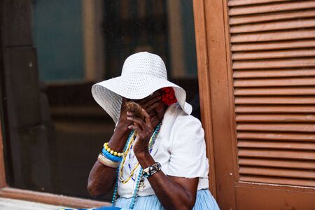 Charismatic Cuban in national costume with handmade cigars on Havana streetのeditorial素材