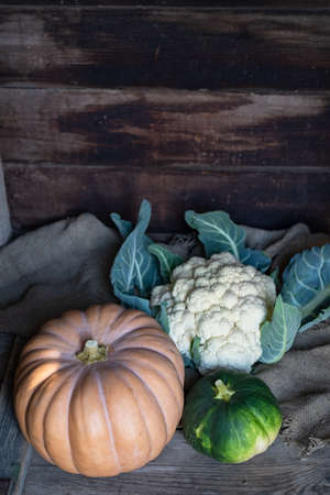 pumpkin and cauliflower on wooden background, close up still life with burlapの写真素材