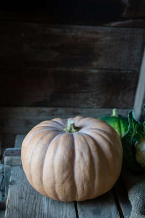Yellow and green pumpkins on the old wooden background, close up still lifeの写真素材