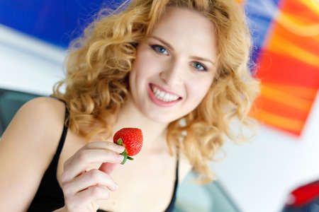 Young woman with strawberry near New carの写真素材