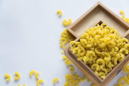 Italian food concept and menu design with copy space. Uncooked yellow pasta in wood box. Flat lay.の写真素材