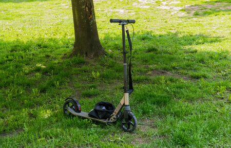 Close up electric scooter onthe green grass in summer sunny day. Healthy lifestyle.の写真素材