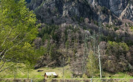 A little old wood house between mountains with much trees. Nature background with Alps in Switzerland, Europe.の写真素材