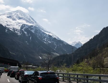A lot of Cars stay in traffic jam on the road with mountains and forest in Switzerland.の写真素材