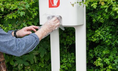 The man with two hands take cellophane gloves on the gas station.の写真素材