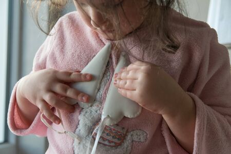 Young beautiful girl with dark hair stay in pink dress and take two white porcelain hearts. Sign of love in Valentines or Mothers Day.の写真素材