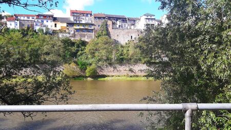 Street with much colorful houses near the river and trees in summer time.の写真素材
